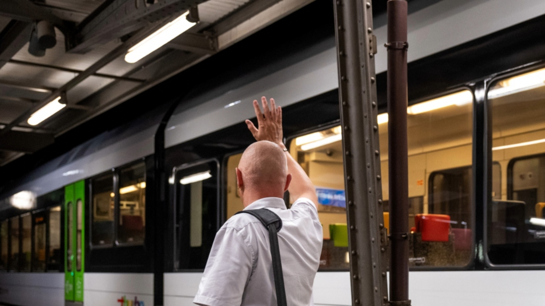 Kundenbegleiter vor einem Thurbo Zug winkt jemanden.